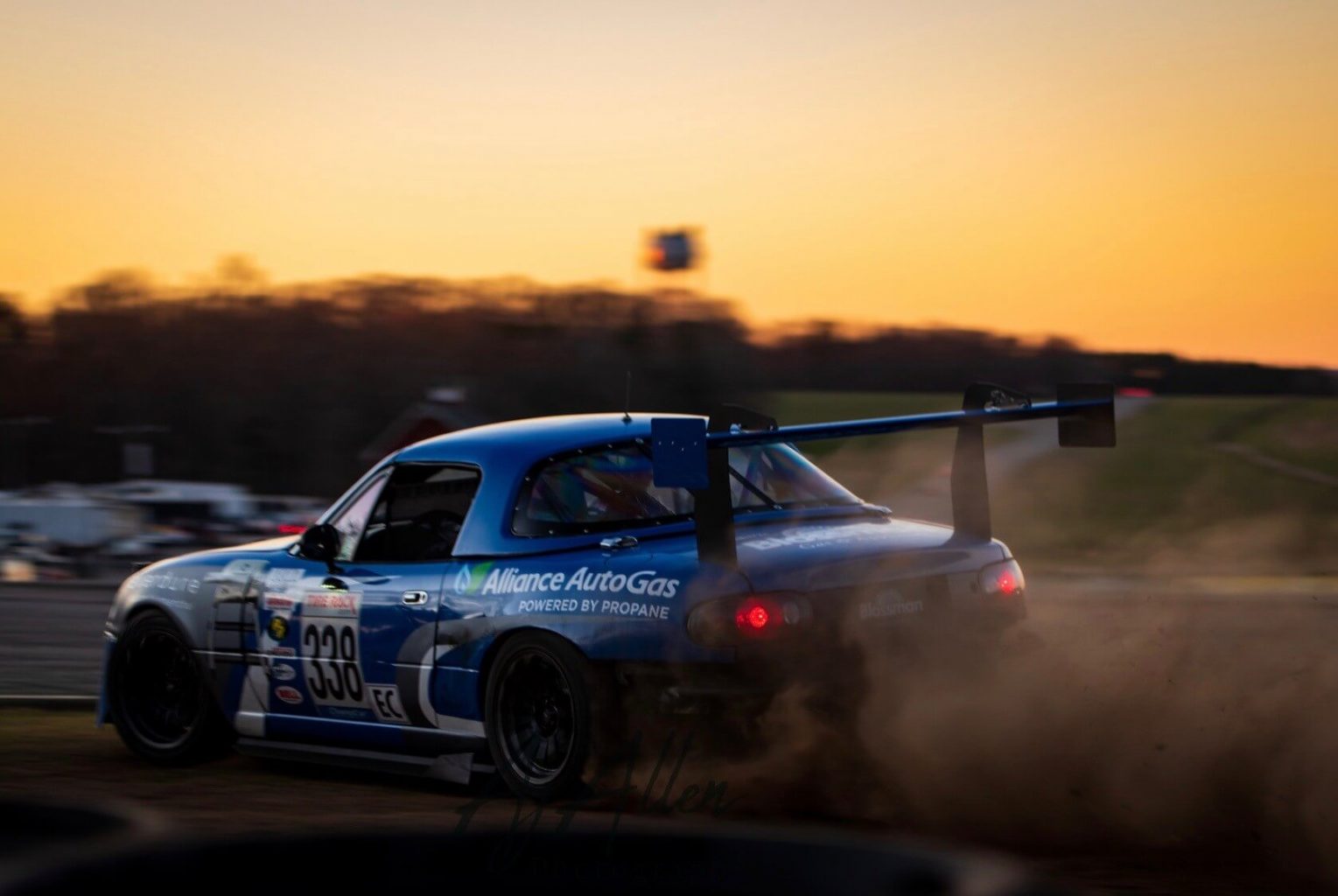 FiveTales Racing Blue Racecar on Track Racing During Sunset