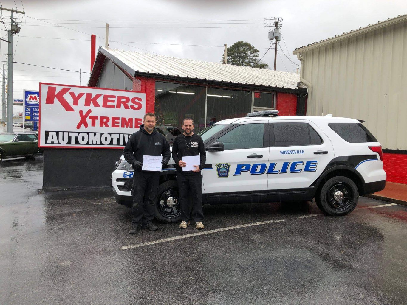 Kykers Xtreme Automotive newly trained propane autogas service techs pictured in front of propane autogas police vehicle